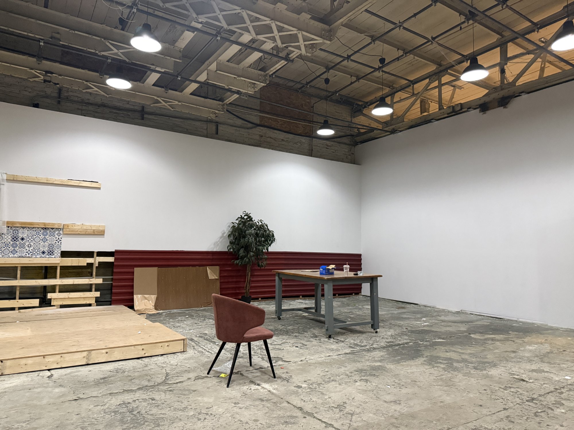 White wall and a raised platform on the studio floor at 252 Stuart Street